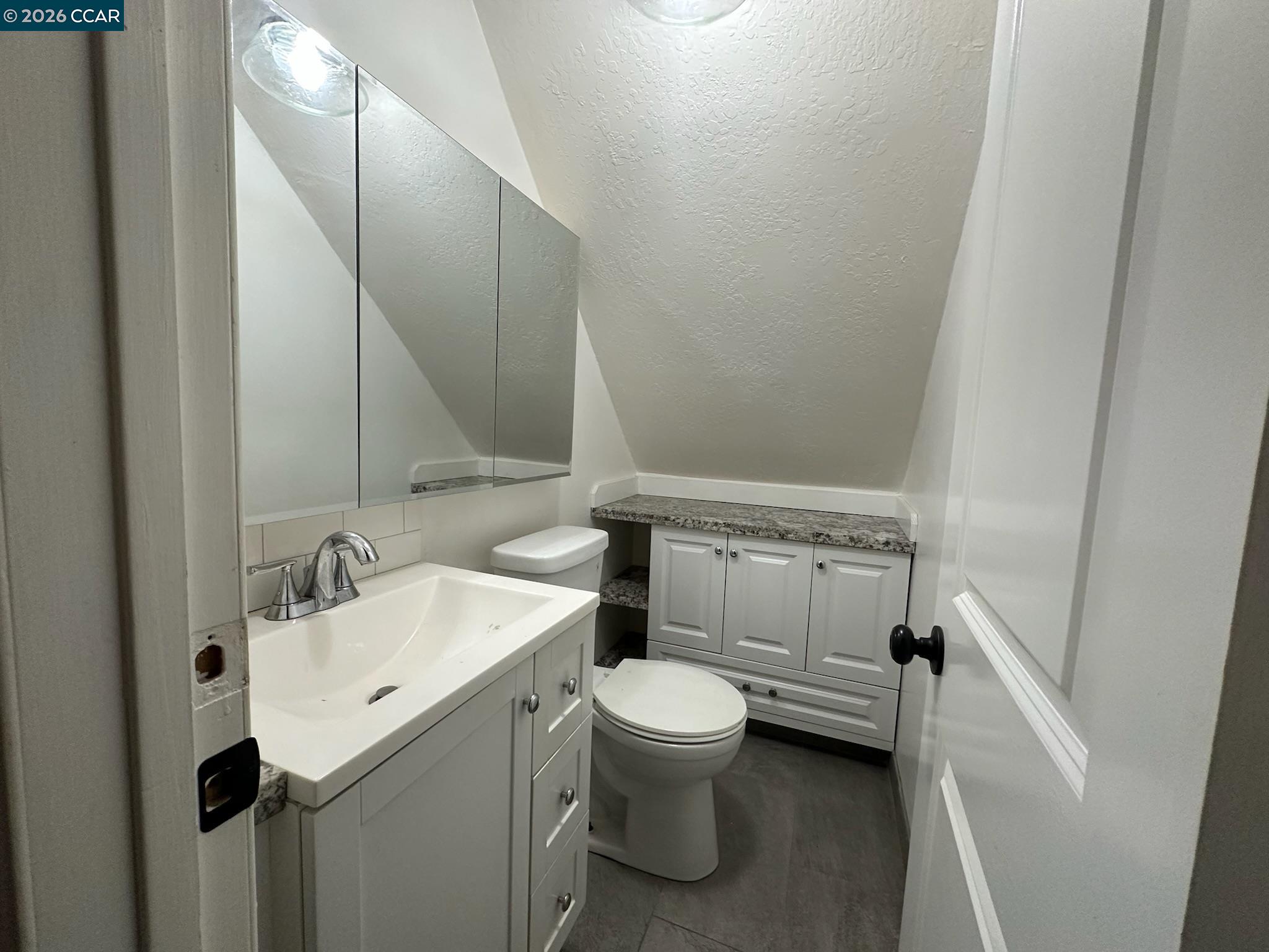 315 West 3rd Street, Unit B Antioch, CA 94509 - Photo 28 of 41 a bathroom with a sink and mirror with toilet