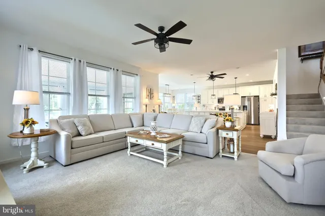a living room with furniture and a ceiling fan