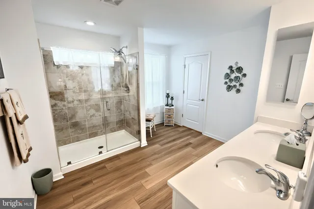 a bathroom with a sink mirror and a shower