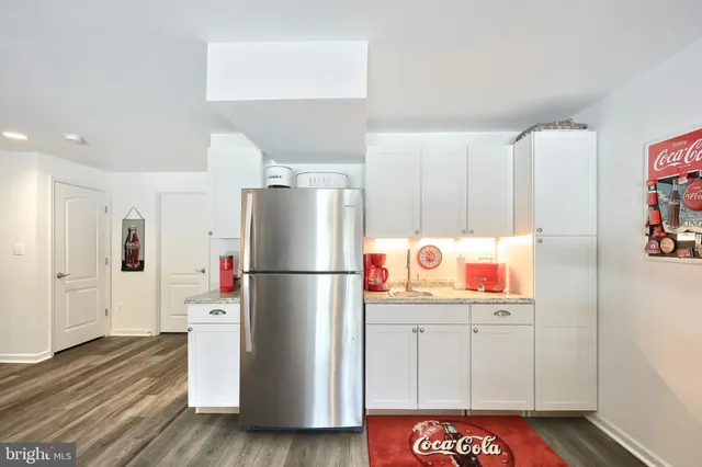 a living room with furniture and a refrigerator