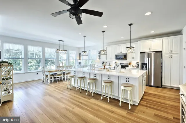 a large kitchen with kitchen island a large window a island a counter space and stainless steel appliances