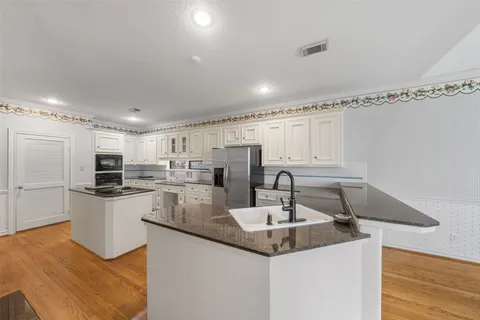 a kitchen with a sink and white cabinets