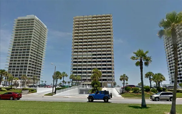 a view of tall buildings and cars parked