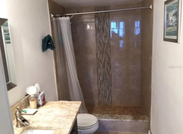 a bathroom with a sink toilet and shower