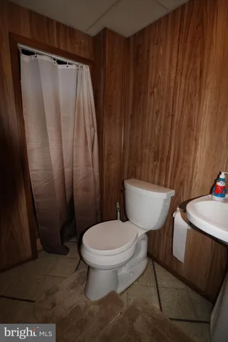 a white toilet sitting next to a shower curtain