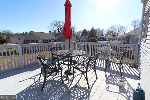 a view of a roof deck with table and chairs and wooden floor