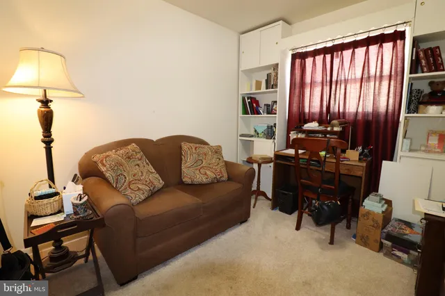 a living room with furniture a lamp and a window