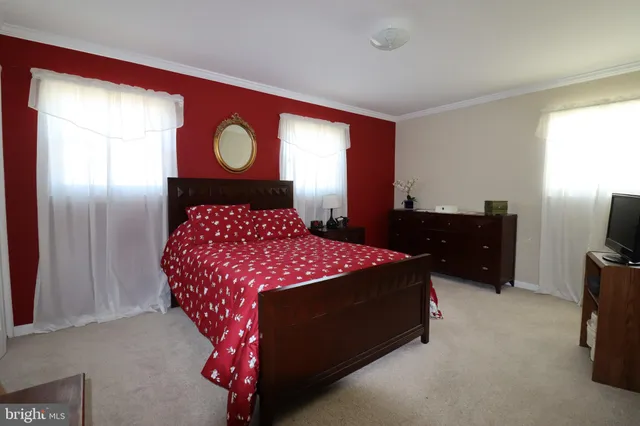 a bedroom with a bed and a lamp on dresser