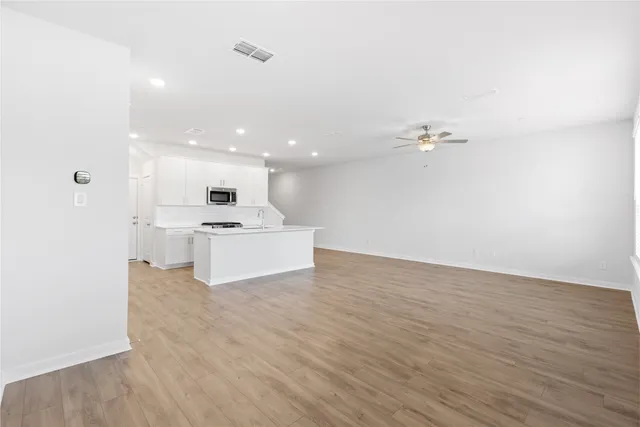 a view of empty room with wooden floor