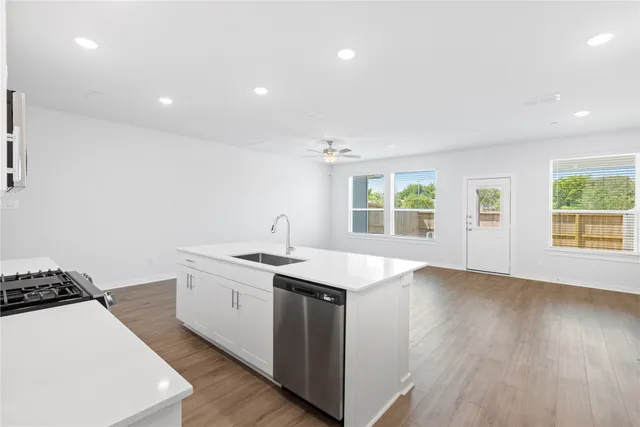 a kitchen with stainless steel appliances a white stove top oven sitting next to a window