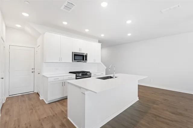 a view of kitchen with sink and refrigerator