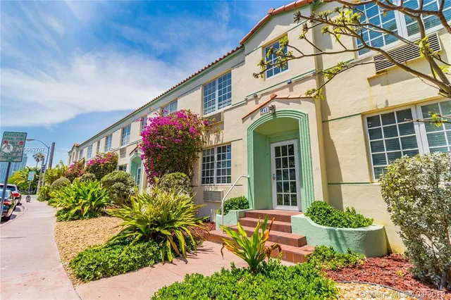 a front view of a house with lots of potted plants