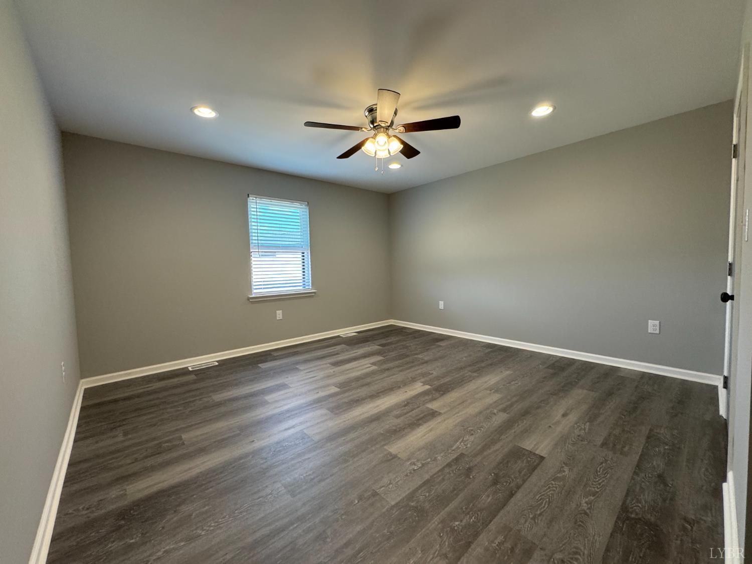 3941 Promise Land Road Appomattox, VA 24522 - Photo 8 of 21 an empty room with wooden floor ceiling fan and windows