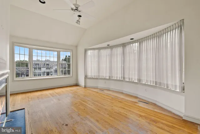 a view of an empty room with a fireplace and a window