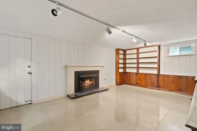 a view of empty room with a fireplace and cabinet