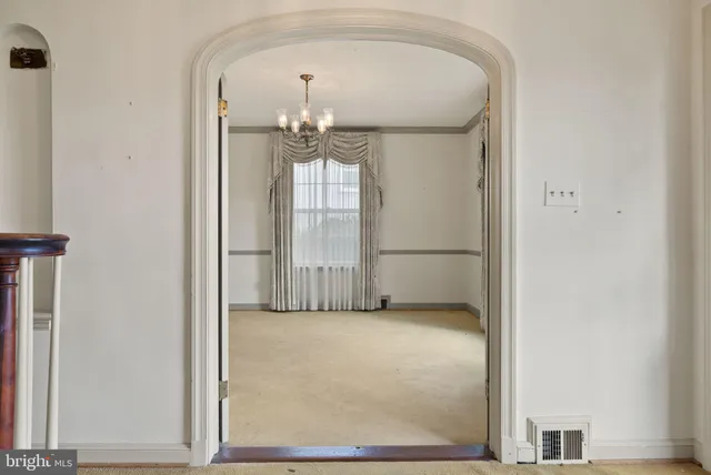 a view of empty room with chandelier