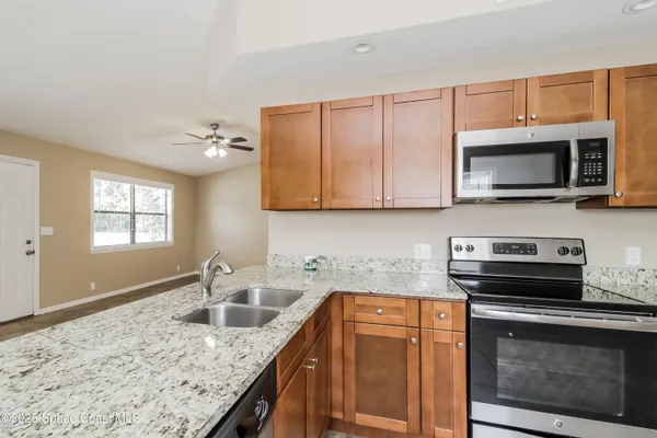 a kitchen with stainless steel appliances granite countertop a sink stove and microwave