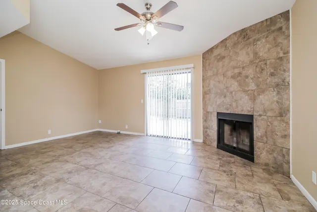 a view of an empty room with a fireplace and a window