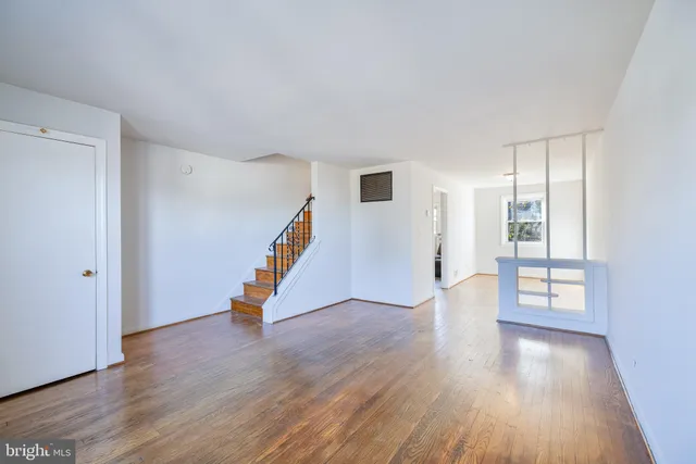 an empty room with wooden floor and stairs