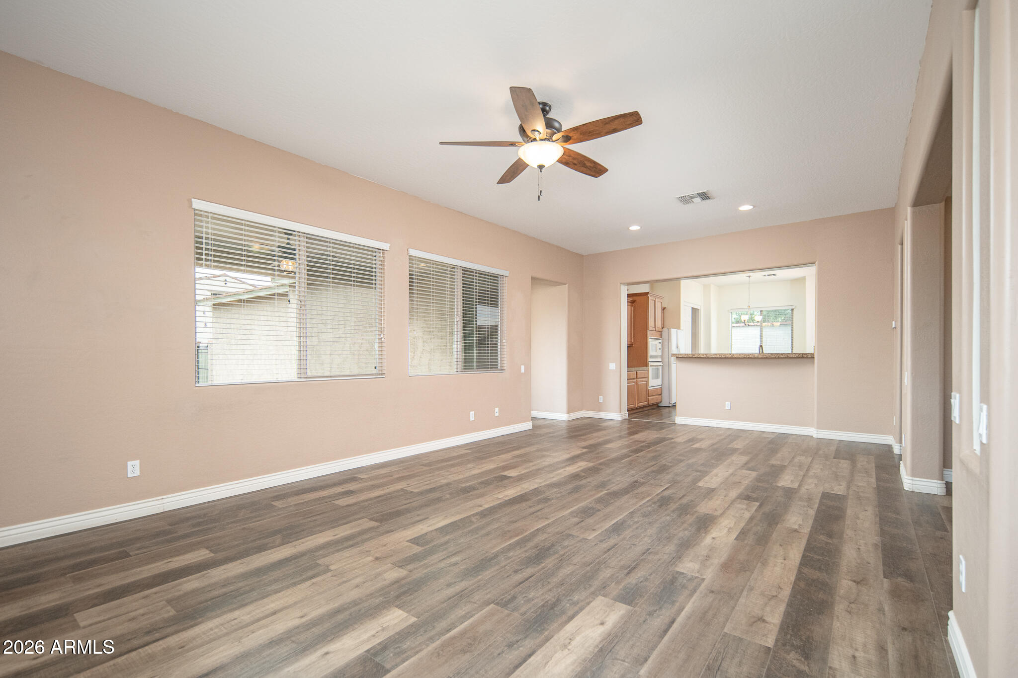 20377 West Shadow Street Buckeye, AZ 85396 - Photo 3 of 37 a view of an empty room with a window and wooden floor