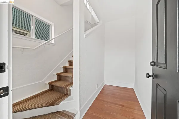 a view of a hallway with wooden floor and entryway