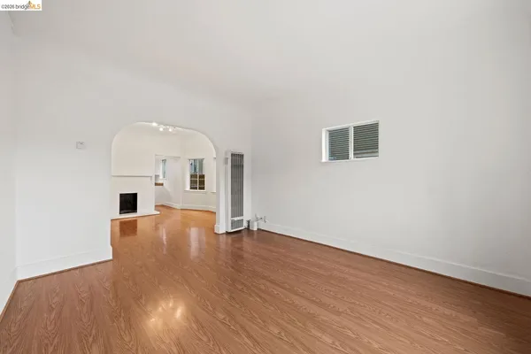 an empty room with wooden floor and fireplace