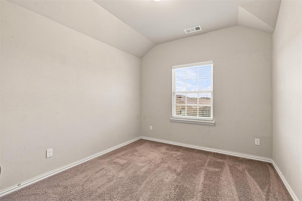 1321 Raleigh Path Denton, TX 76208 - Photo 26 of 35 Windowed room featuring vaulted ceilings, neutral-toned walls, brown carpet flooring, and white baseboards