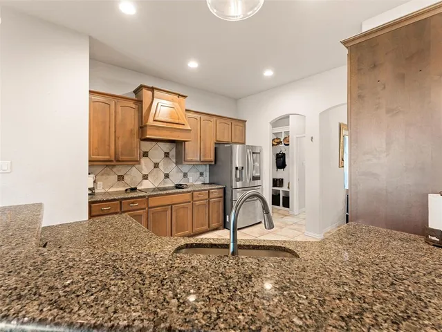 a kitchen with stainless steel appliances kitchen island granite countertop a sink and cabinets