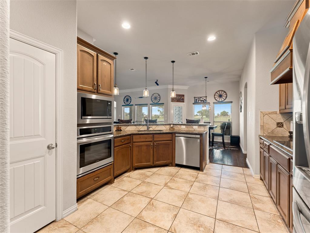 109 Highland Hills Boulevard Decatur, TX 76234 - Photo 15 of 36 a kitchen with stainless steel appliances granite countertop a refrigerator and a stove top oven