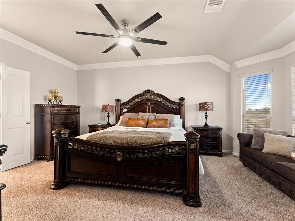 109 Highland Hills Boulevard Decatur, TX 76234 - Photo 18 of 36 a bedroom with a bed and a chandelier