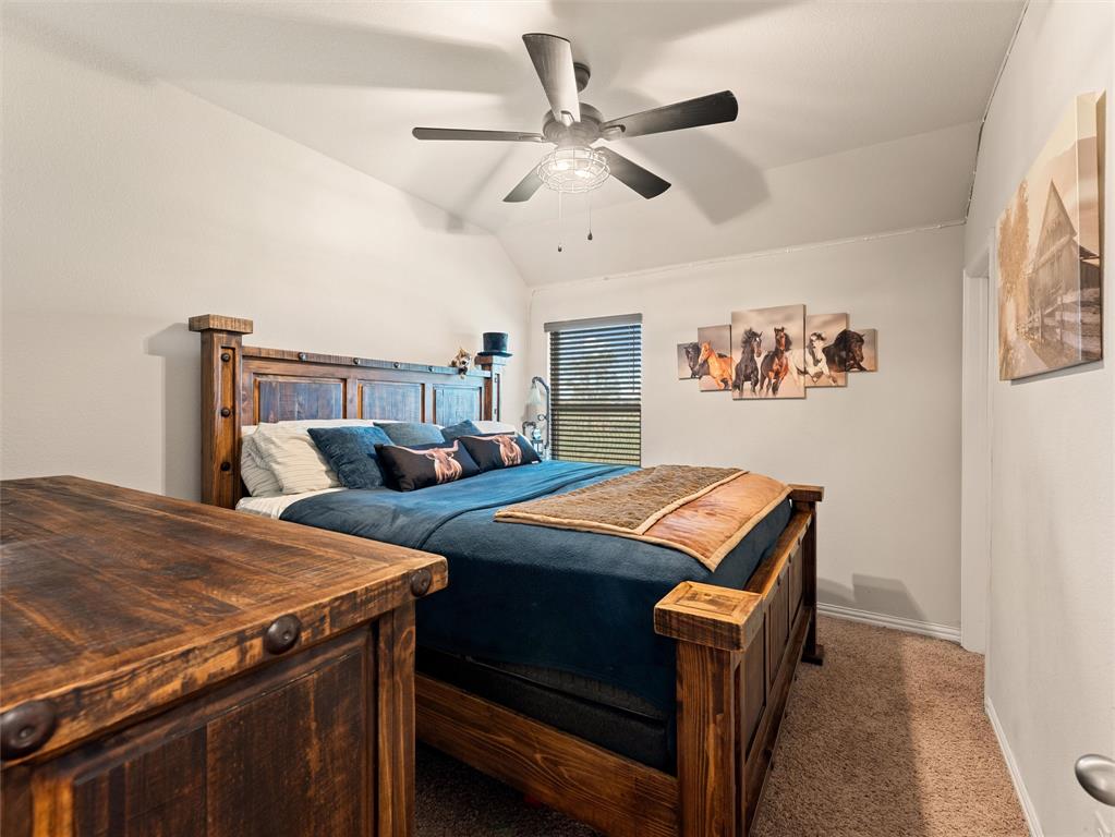 109 Highland Hills Boulevard Decatur, TX 76234 - Photo 23 of 36 a bedroom with a bed and a chandelier