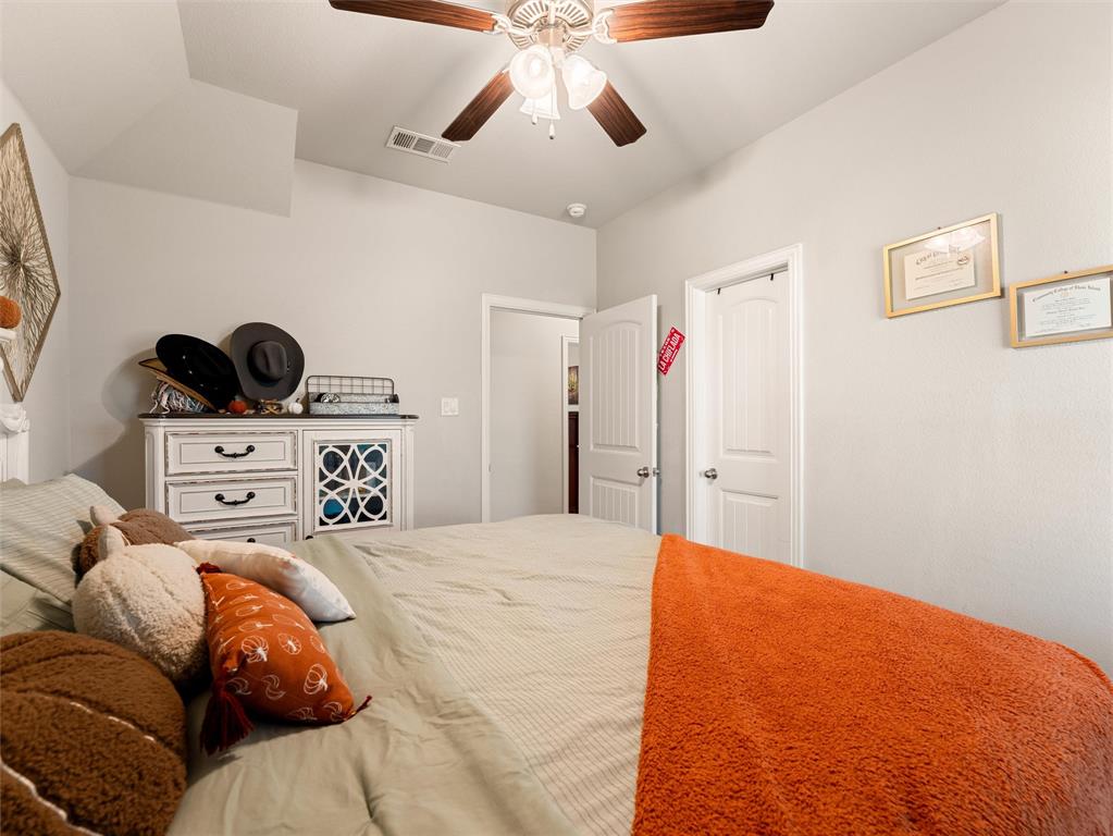 109 Highland Hills Boulevard Decatur, TX 76234 - Photo 26 of 36 a bedroom with a bed and a chandelier