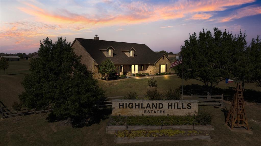 109 Highland Hills Boulevard Decatur, TX 76234 - Photo 35 of 36 a front view of a house with a garden and trees