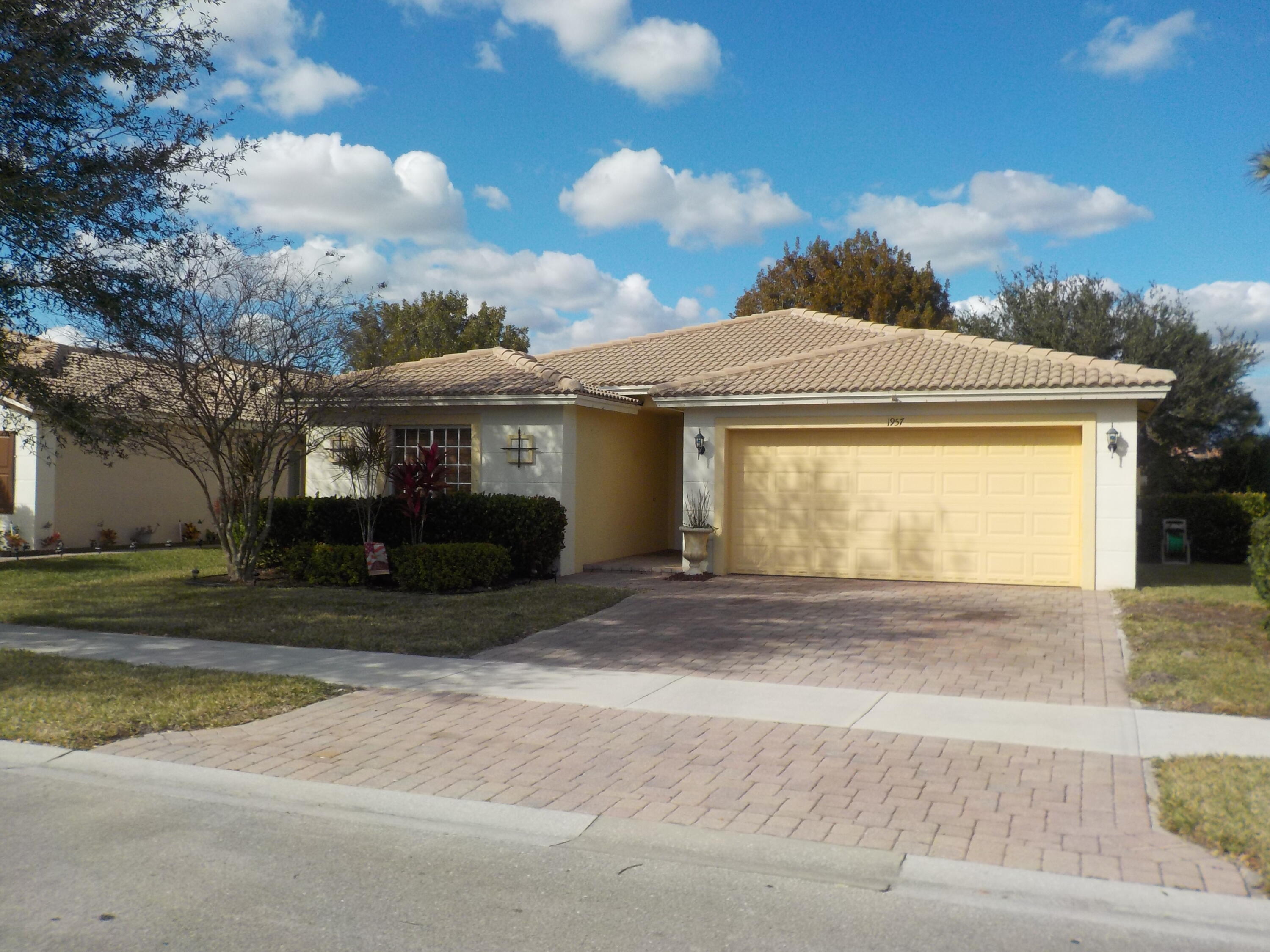 1957 Providence Place Port St. Lucie, FL 34953 - Photo 1 of 15 a front view of a house with a garden