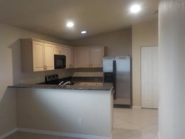 a kitchen with a refrigerator and a stove top oven