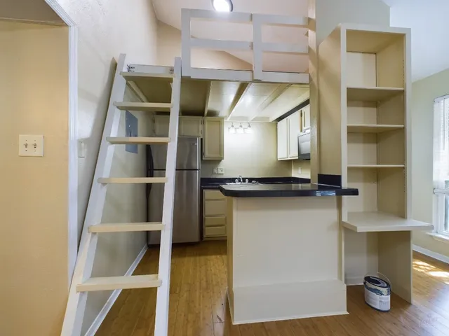 a view of a refrigerator in kitchen and an empty room