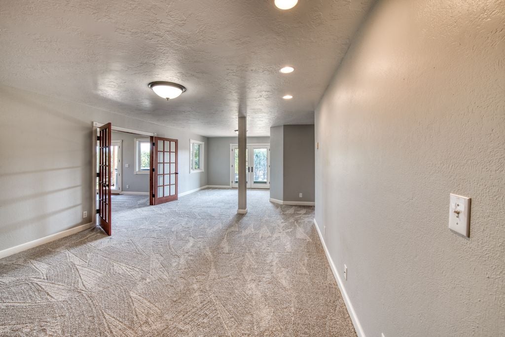 16374 Folsom Road Florence, MT 59833 - Photo 82 of 98 Carpeted empty room featuring a textured ceiling, french doors, a textured wall, and recessed lighting