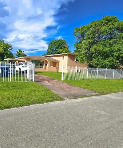 a view of a house with a yard and a street