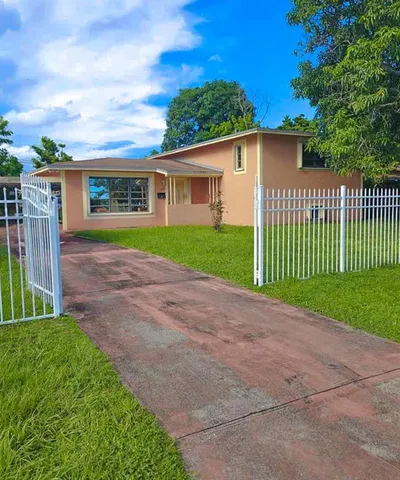 a view of a house with a yard and potted plants