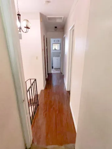 a view of a hallway with wooden floor and staircase