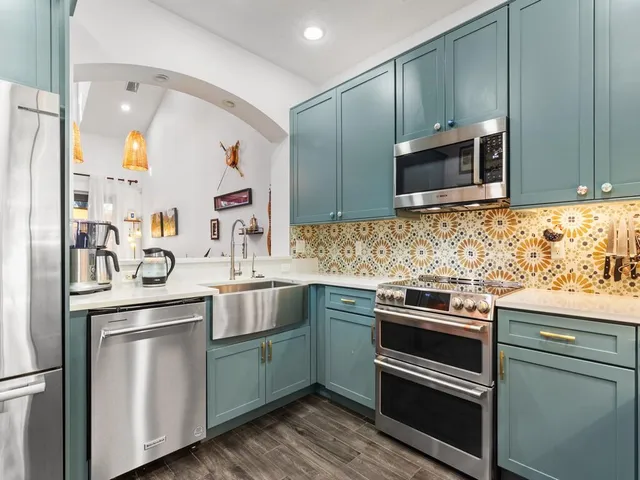 a kitchen with stainless steel appliances granite countertop a sink and cabinets