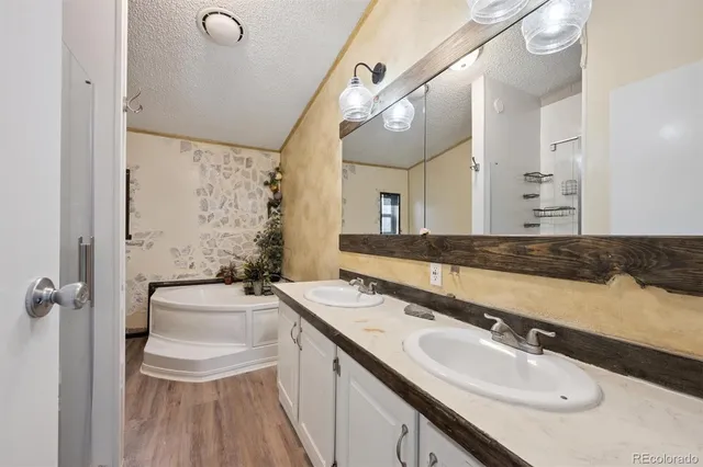 a bathroom with a granite countertop sink a toilet a mirror and shower