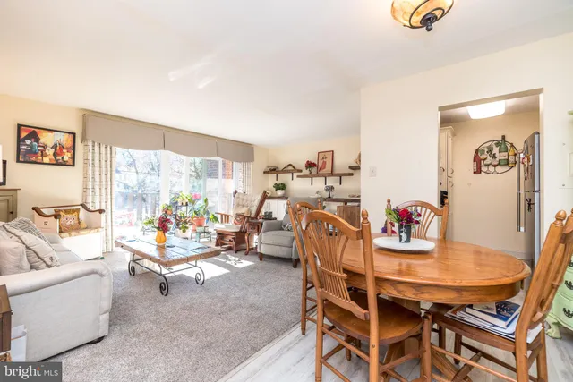 a dining room with furniture and a large window
