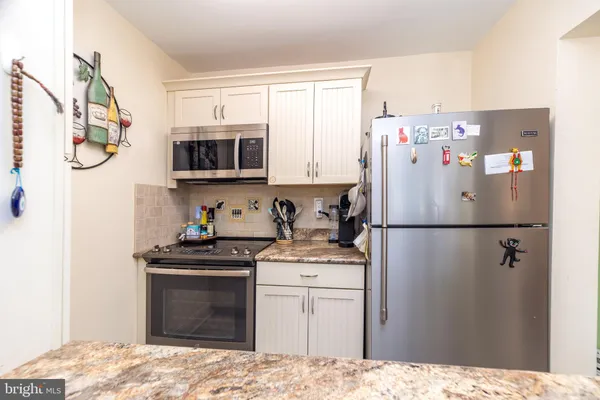 a kitchen with a refrigerator sink and cabinets
