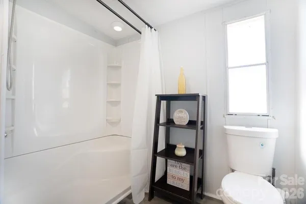 a white toilet sitting next to a bathroom sink and a shower