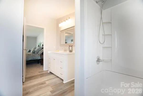 a en suite bathroom with a granite countertop sink and a mirror