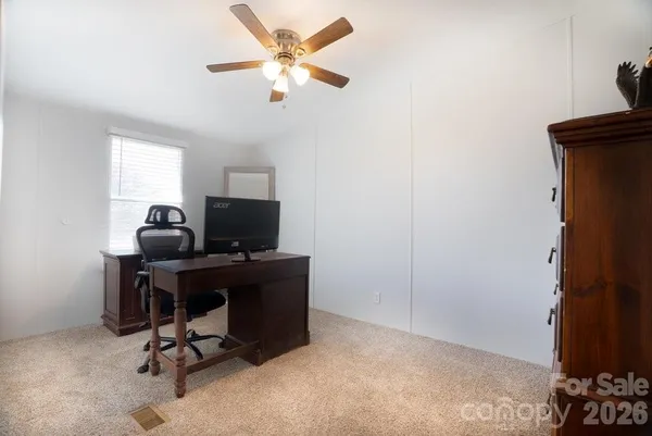 a view of a workspace with furniture and a window