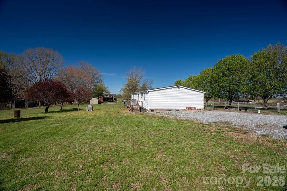 889 Tabor Road Olin, NC 28660 - Photo 27 of 34 a backyard of a house with plants and large trees