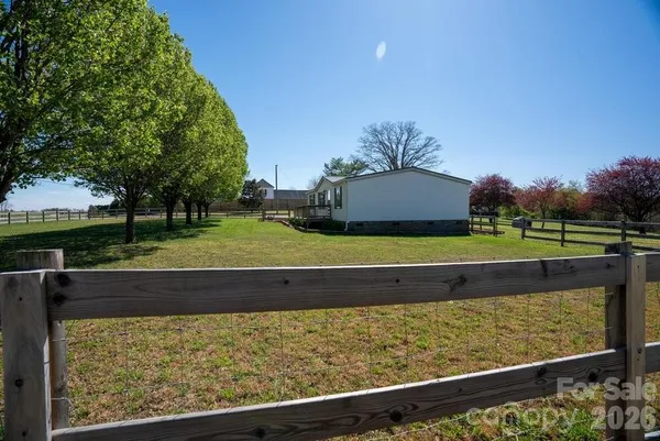 a view of a yard with wooden fence