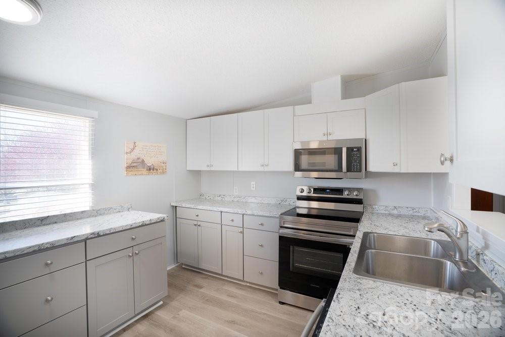 889 Tabor Road Olin, NC 28660 - Photo 9 of 34 a kitchen with stainless steel appliances granite countertop a sink dishwasher stove and oven with cabinets